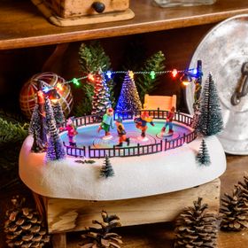Weihnachtsdorf, rotierende Schlittschuhläufer auf Eisbahn, Weihnachtslieder