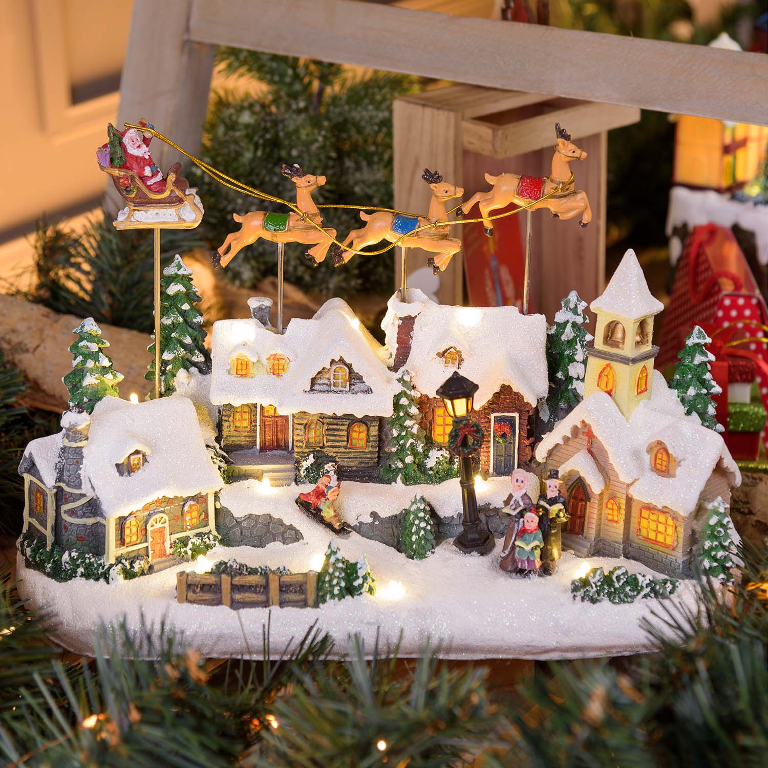 Snowy Village with Church and Father Christmas on Flying Sleigh with Moving Reindeer, h 23 cm, Christmas music Snowy Village with Church and Father Christmas on Flying Sleigh with Moving Reindeer, h 23 cm, Christmas music